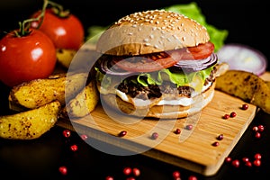 Hamburger with meat patty and cheese. bacon and fresh vegetables