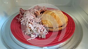 Hamburger with pork on red plate in microwave