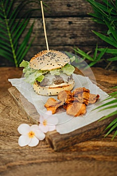 Hamburger with potatoe chips on wooden background