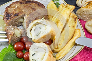 Hamburger steak with potatoes, cherry tomatoes and olive bread o