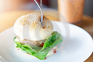 Hamburger in a white ceramic dish at restaurant