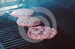 Hamburgers on Grill with Flames Cooked to Perfection photo