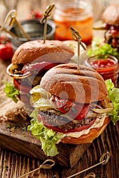 Hamburgers, homemade burgers with grilled buns with addition of addition of beef cutlet, lettuce, tomato,pickled cucumber, grille photo