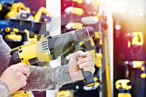 Hammer drill in hands at shop