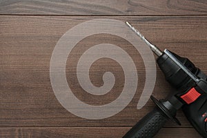 Hammer drill on the wooden background with copy space