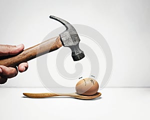 Hammer and egg with anxious face