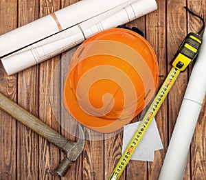 Hammer, folding ruler, blueprint and yellow safety helmet