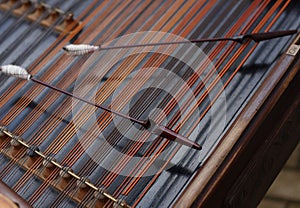 Hammer laying on the strings of the cimbalom photo