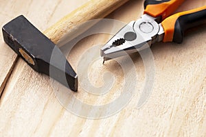 Hammer, nails and pliers lie on a wooden background. Construction Tools Selective Focus