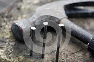 Hammer and nails on a wooden blurred background