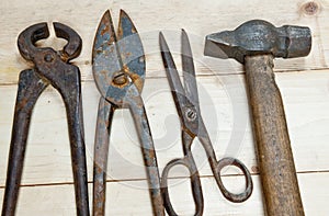 Hammer and nippers on wood background