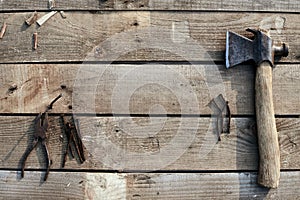 A hammer, pliers and bent nails old lie on a tree desktop. rust. cracked, scratched homemade table. construction background