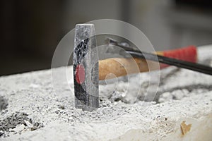 Hammer, pliers on a piece of masonry as a symbol for construction freeze and construction site