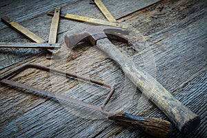 Hammer, Saw and Measuring Tape on Rustic Wood