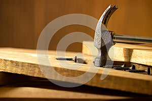 Hammer and screw on lumber in lighting and shadow of the sunshine in morning.