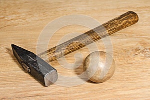 Hammer and wooden ball on a wooden surface