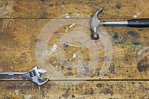 Hammer and wrench on work workshop bench background