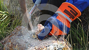 Hammering with a geologists hammer on stone