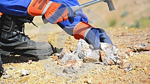 Hammering with a geologists hammer on stone