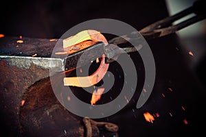 Hammering glowing steel - to strike while the iron is hot.