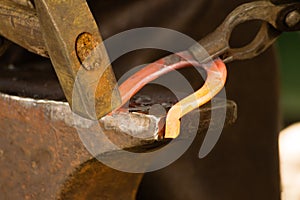 Hammering glowing steel - to strike while the iron is hot.