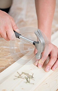 Hammering nails into wooden board