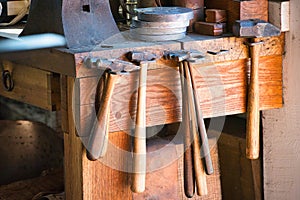 Hammers hanging on a bench in a blacksmith shop.