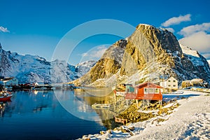 HAMMNOY, LOFOTEN, NORWAY, APRIL, 10, 2018: Above view of some Fishing hut rorbu and Lilandstinden mountain peak at