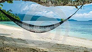 Hammock on the Beach, Batu Lima, Coral Reef of an Homestay Gam Island, West Papuan, Raja Ampat, Indonesia