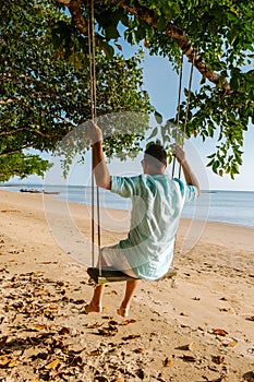 Hammock on the beach Krabi Thailand, guy in swing on Ao Nang beach Thailand Krabi