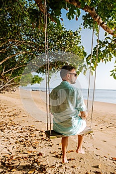 Hammock on the beach Krabi Thailand, guy in swing on Ao Nang beach Thailand Krabi