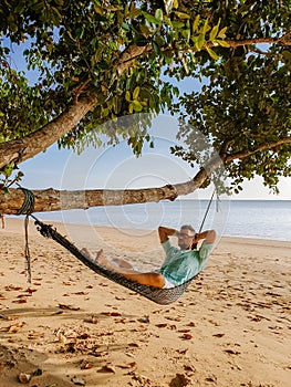 Hammock on the beach Krabi Thailand, guy in swing on Ao Nang beach Thailand Krabi