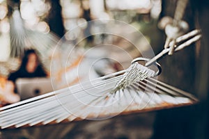 Hammock hook close-up, relaxation concept, woman with laptop in the background