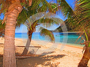 Hammock next to a turquoise tropical lagoon