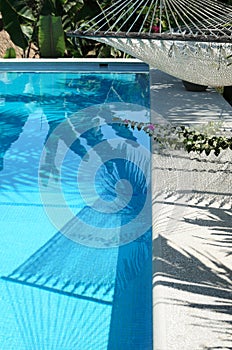 Hammock over swimming pool and its shadow in it