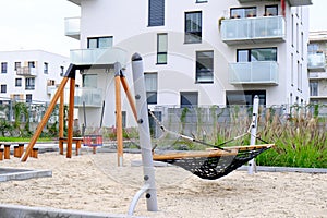 Hammock and swing on a children playground in cozy courtyard of modern residential district