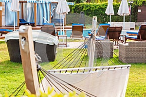 hammock on terrace with round sun chairs near swimming pool