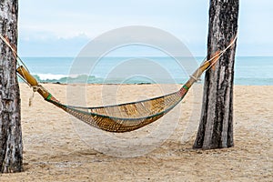 Hammock between two coconut trees on a tropical island with beautiful beach