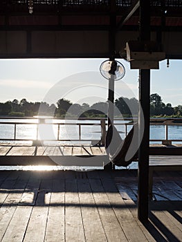 Hammock in wood house near river before sunset in Lao