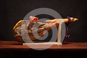 Hamon - leg of dried pork meat - on a wooden stand.