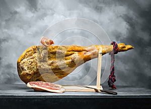 Hamon - leg of dried pork meat - on a wooden stand. photo