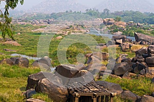 Hampi village Tungabhadra river meadow. Landscape with water, palm, rock, stones. India, Karnataka