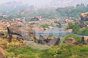 Hampi village Tungabhadra river meadow. Landscape with water, palm, rock, stones. India, Karnataka