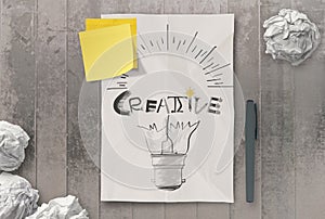 Han drawn light bulb and CREATIVE word design on clumpled paper