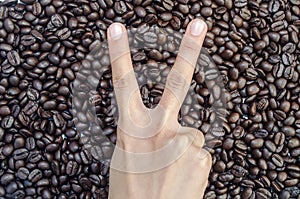 Hand `2 finger` on coffee beans