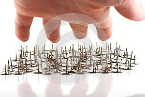 Hand above thumb tacks - drawing pins