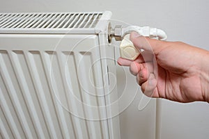 Hand adjusting the knob of heating radiator individual heating system
