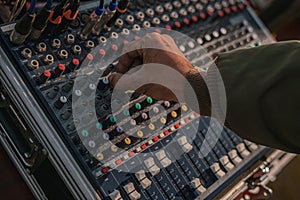 Hand adjusting knobs on a sound mixing console