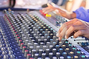 Hand adjusting volume sound of mixer,