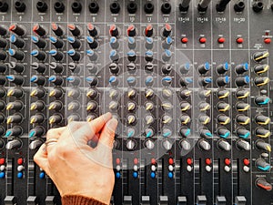 hand adjusts audio mixer